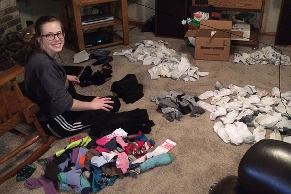 Co-founder Josie Jensen sorts through socks donated to Put A Sock In It. To date, the group has distributed more than 3,000 pairs of used socks to people in need.