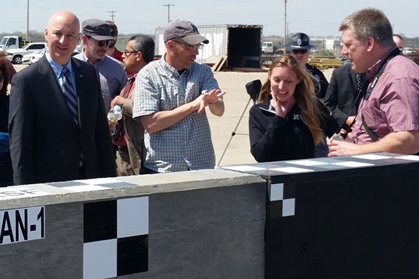 Nebraska Gov. Pete Ricketts (left), talks with Midwest Roadside Safety engineers Robert Bielenberg and Jennifer Schmidt and Manitoba Infrastructure and Transporation design engineer Andy Pankratz as the inspect the concrete barrier.