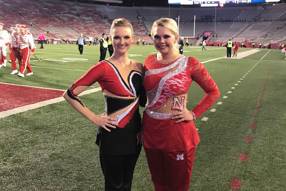 Kimberly Law (left), a freshman in chemical engineering, and senior Hannah Kollman are the featured twirlers this year with the Cornhusker Marching Band. (Photo from twitter.com/UNLTwirlers)