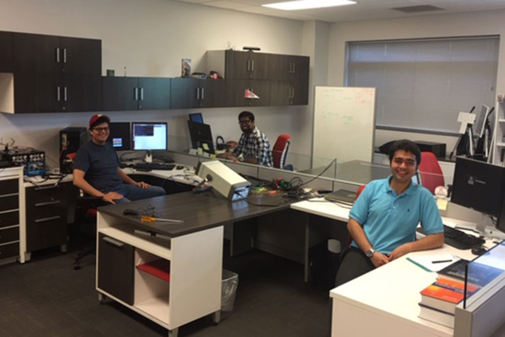 Carlos Brito (left) pauses with fellow researchers in the Advanced Telecommunications Engineering Laboratory in electrical and computer engineering.