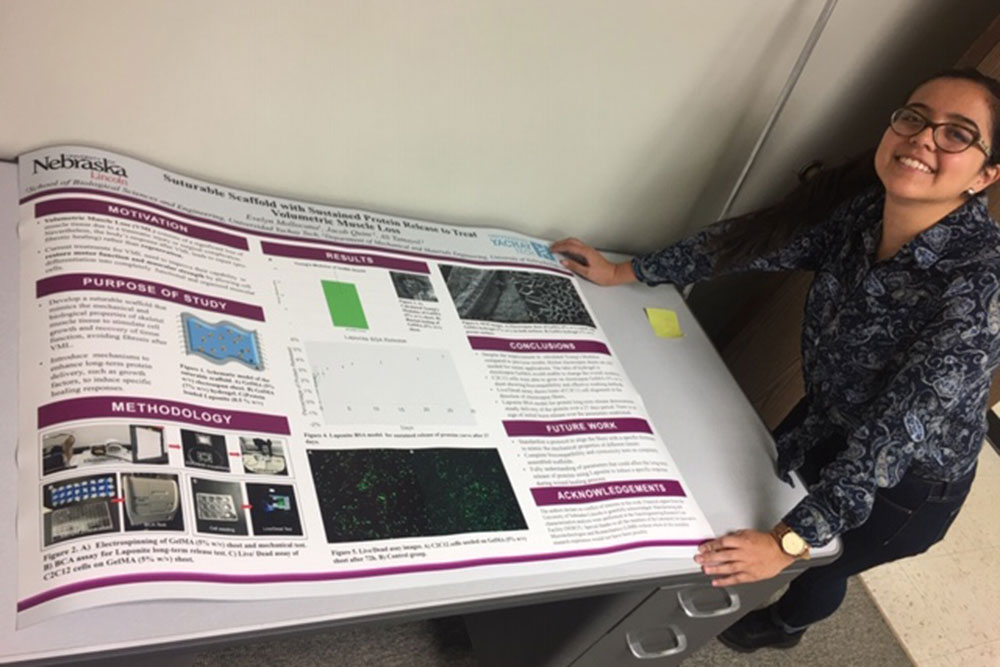 Evelyn Mollocana displays a poster of her research done in Laboratory for Innovative Microtechnologies and Biomechanics (LIMB) in mechanical and materials engineering.