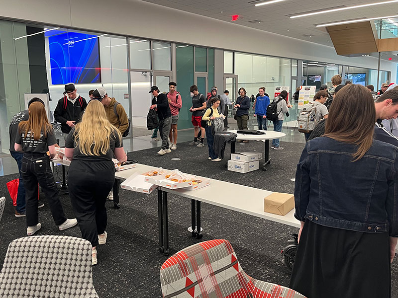 Students line up for donuts with engineering faculty during E-Week 2024.