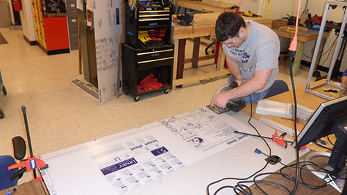 Ethan Monhollon works on panels for the frame assembly to hold the 2014 UNL Microgravity Team project.