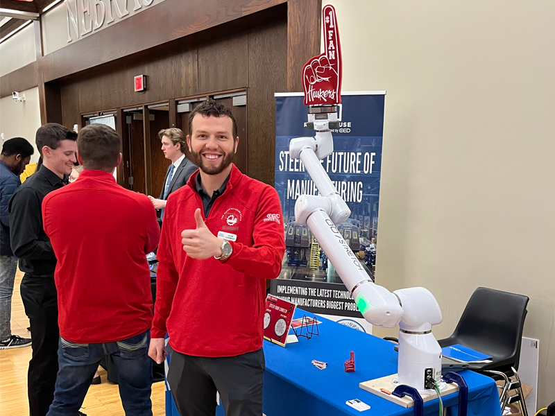Adam Learmont gives an enthusiastic “thumbs up” while the robotic arm at the Rensenhouse (formerly CED Nebraska) booth is an emphatic “No. 1” Husker fan during the 2024 Spring Career Fair Feb. 15 at the Nebraska Union.