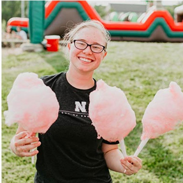 Young woman smiling with cotton candy.