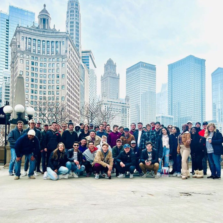 Group of students pose in front of the Chicago skyline.