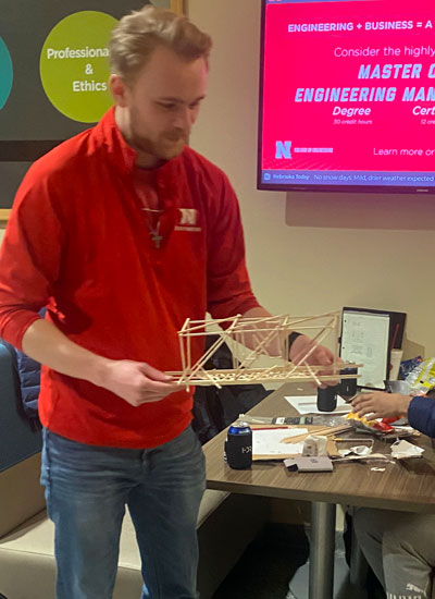 Student builds a model bridge during E-Week 2022