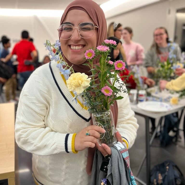 Student pose for a photo with flowers.
