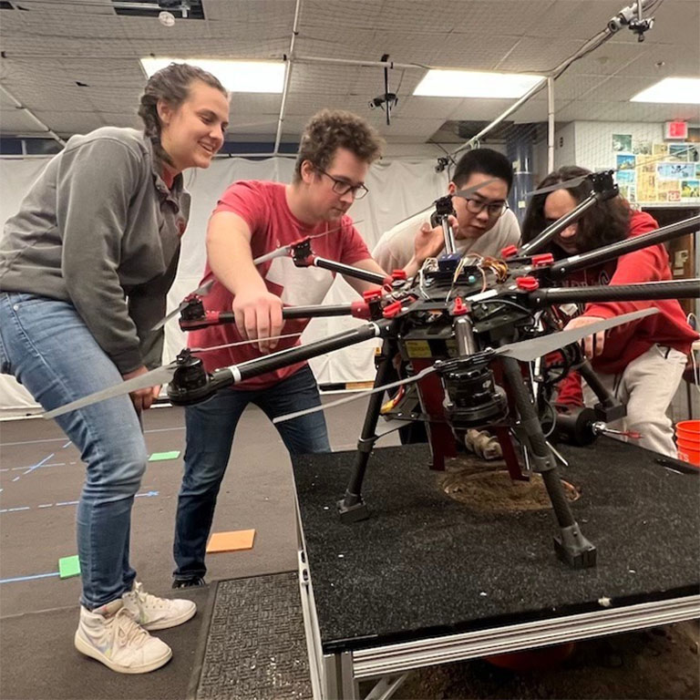 Group of students working with a large drone.