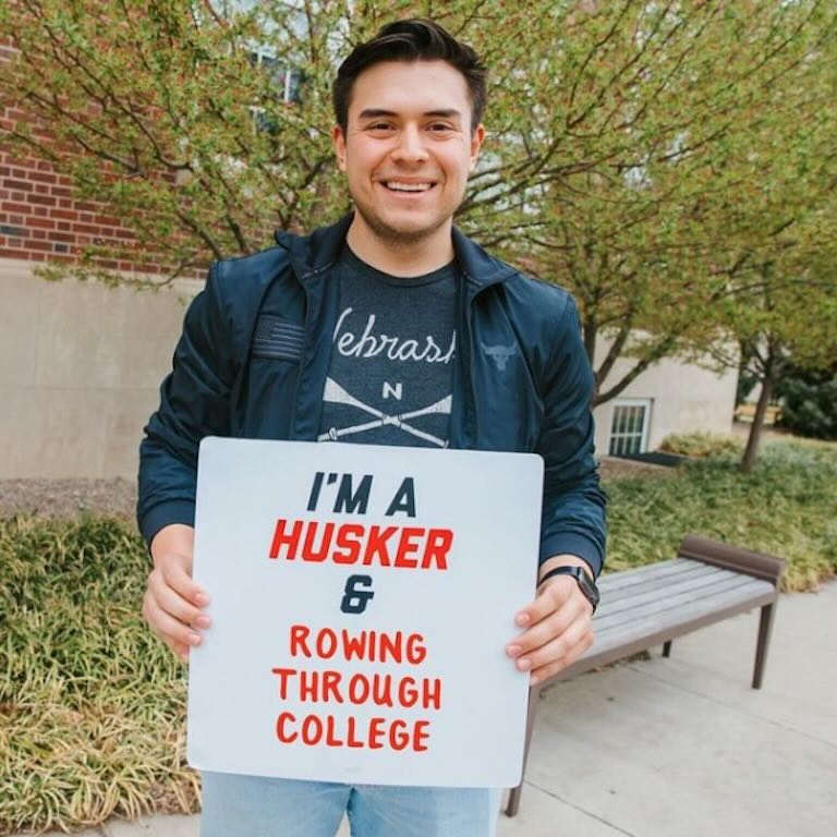Student holding holding I'm a Husker and rowing through college