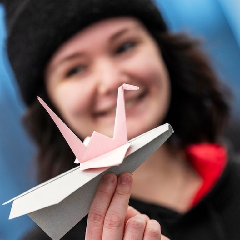 Student holding paper airplane for competition inside Kiewit Hall on the University of Nebraska-Lincoln campus.