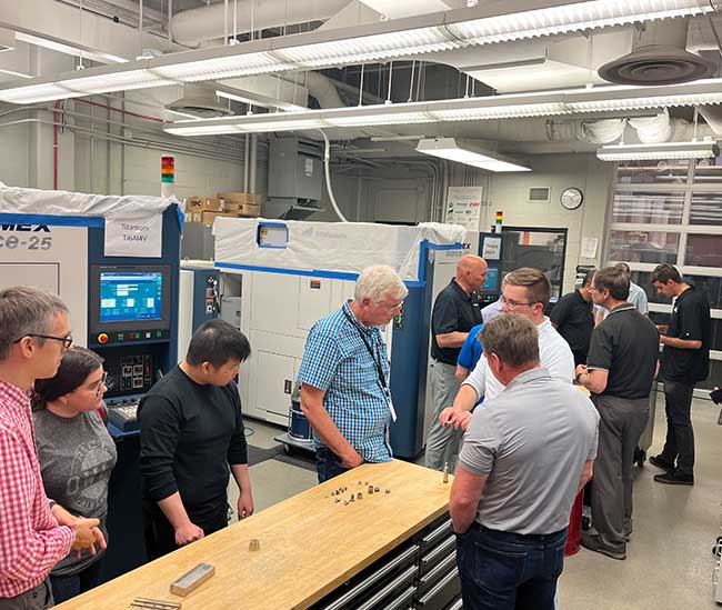 Engineers from Nebraska companies are shown around during an open house for the Nebraska Engineering Additive Technology (NEAT) Laboratories.