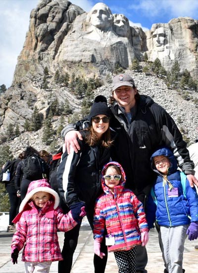 Stephani Bazata and family take a family photo in front of Mount Rushmore.