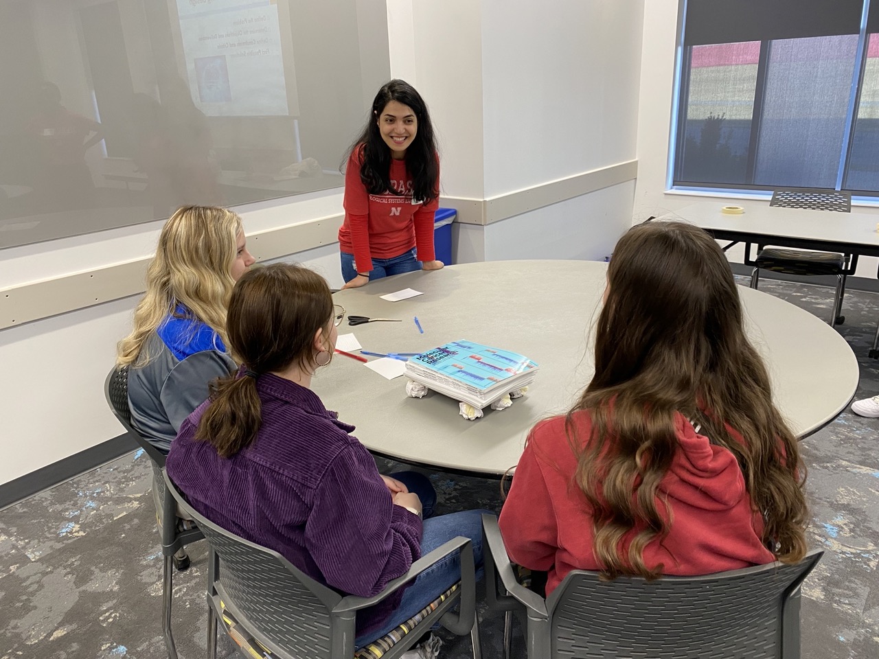 Introducing high school girls to the world of engineering by running a Women in STEM event! Graduate student Samereh Soleimani (shown in picture) is working on increasing STEM outreach through this event. They were tasked to build a structural support using provided materials.