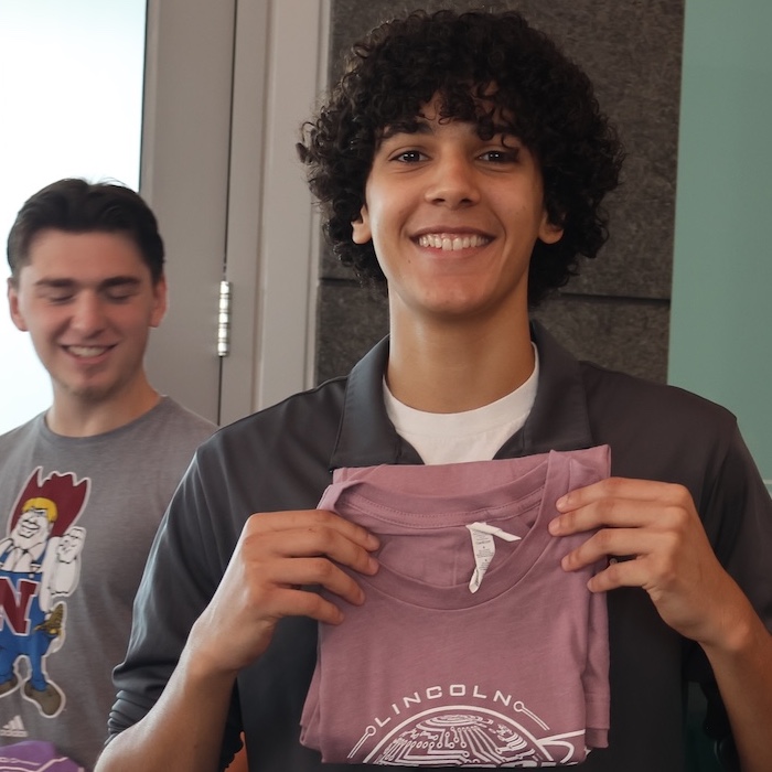 Engineering student holding a college of engineering t-shirt at new student welcome event.