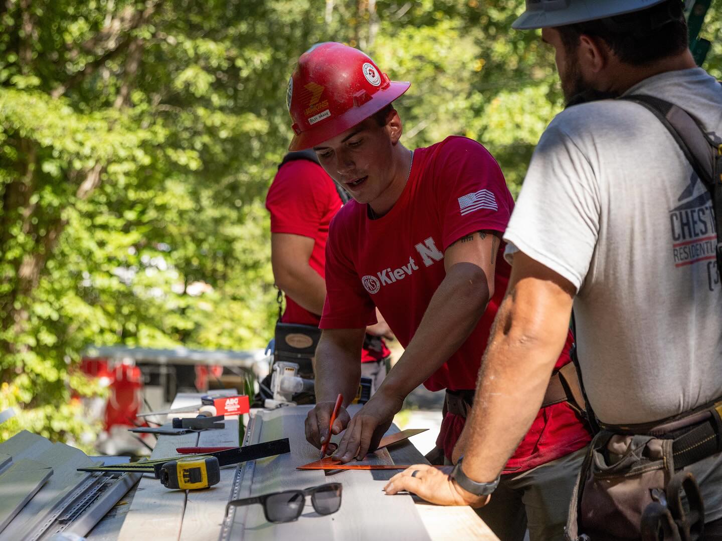 A Nebraska construction management student measures siding for a cut during the annual Race to Build competition in September in Bristol, Tennessee.