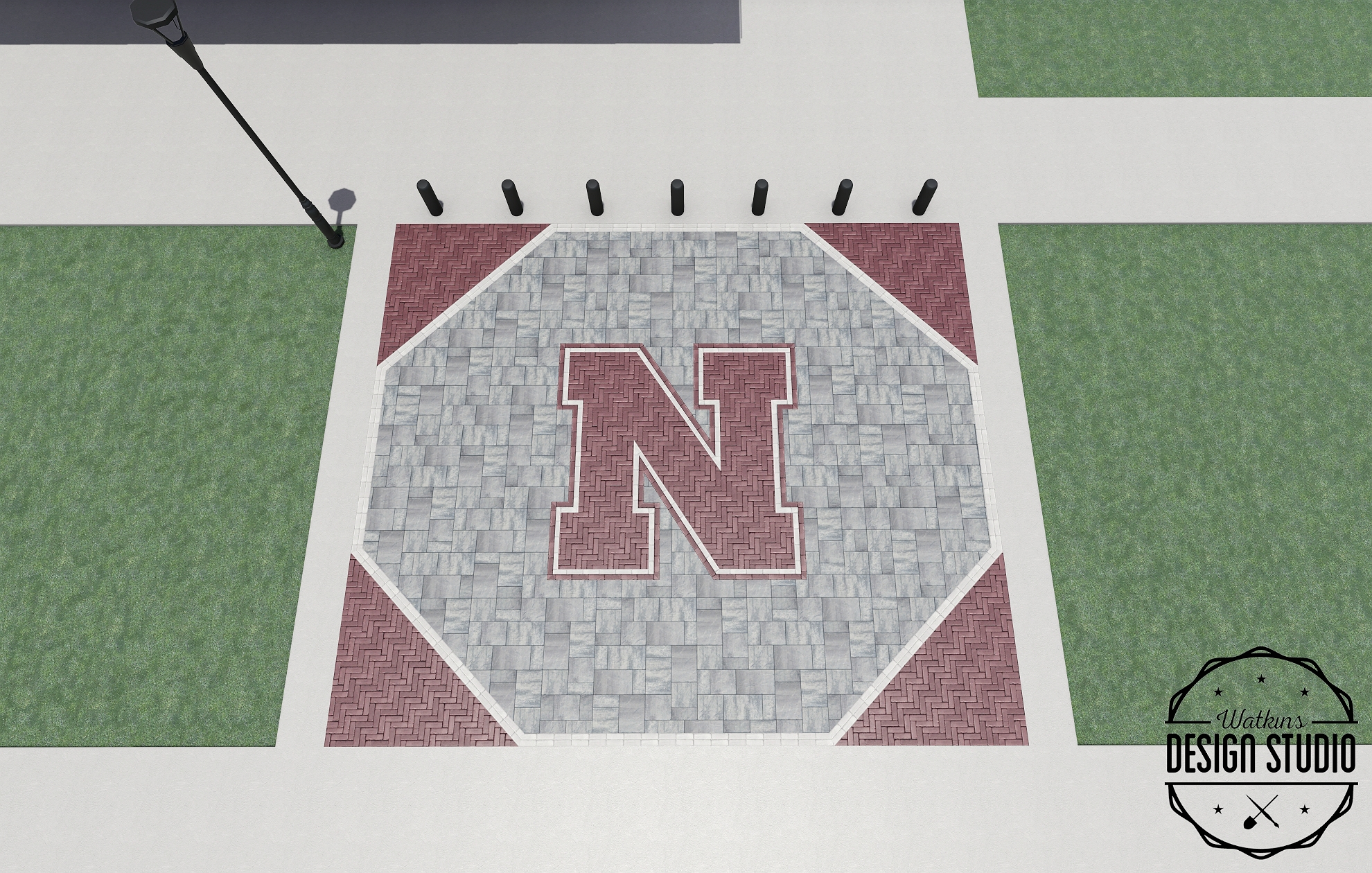 Red "N" emblem on a stone patio surrounded by green grass and bordered by red bricks.