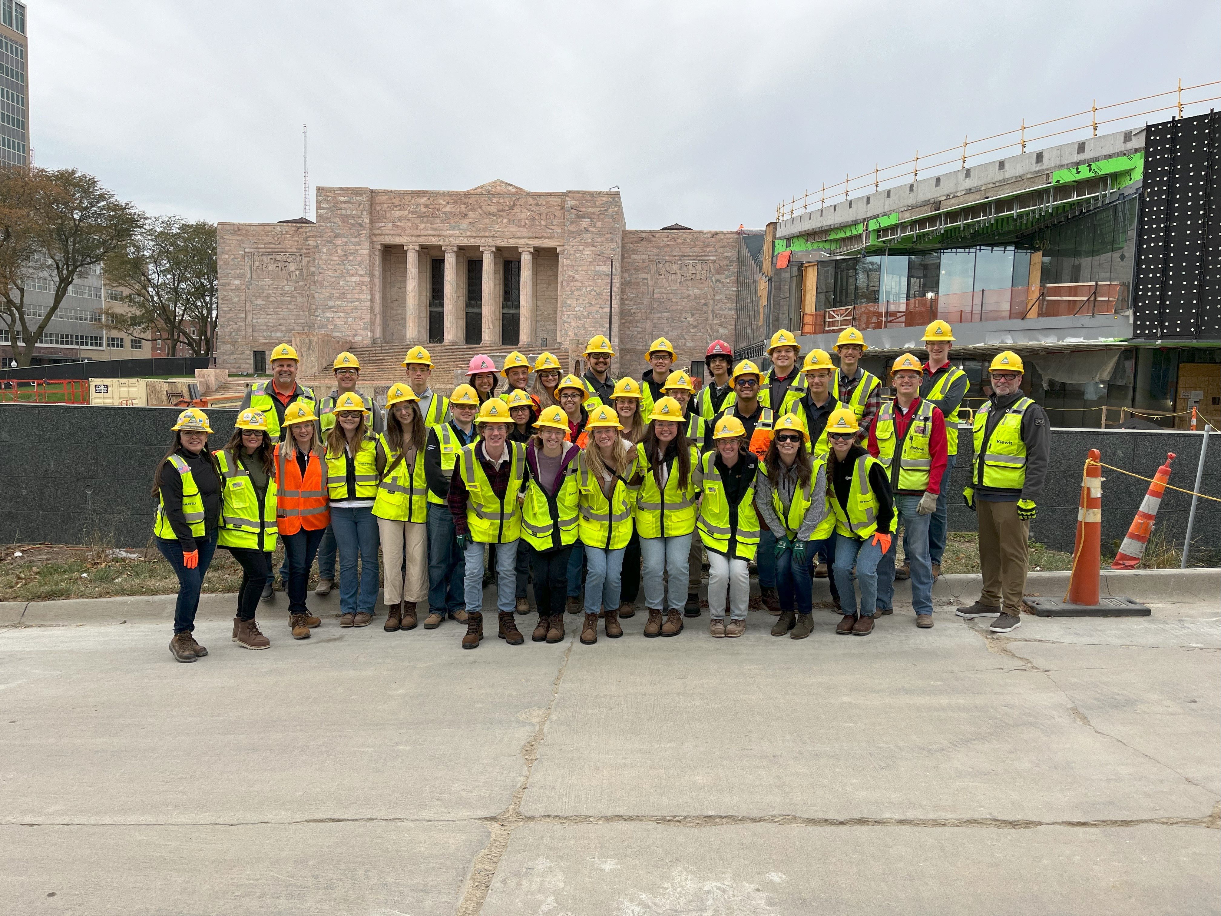 Group of scholars in construction PPE smiling in front of the Joslyn Art Museum