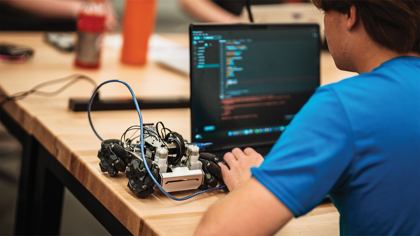 A robotics student adjusting code