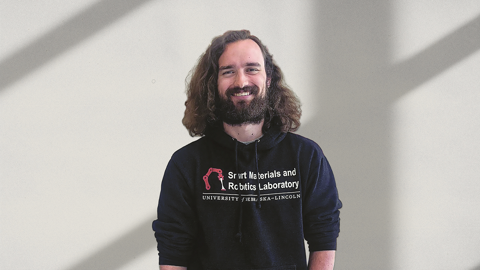 Electrical & Computer Engineering doctoral student, Patrick McManigal, standing infront of a wall.