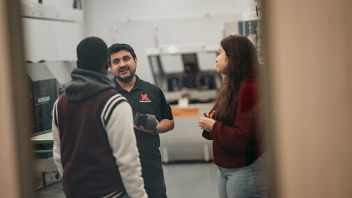Student workers go over material composition with a visiting student.