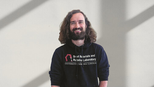 Electrical & Computer Engineering doctoral student, Patrick McManigal, standing infront of a wall.