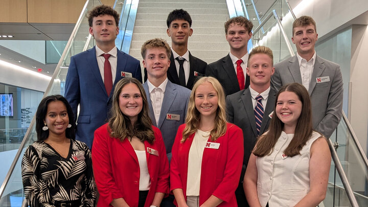 Six young men and four young women pose for a group photo on a staircase.