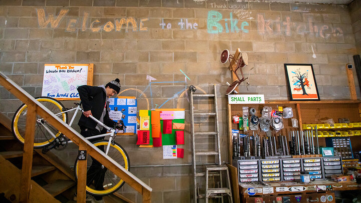Jacob Dalton, a junior majoring in electrical engineering, carries a bike down from storage in the Lincoln Bike Kitchen.