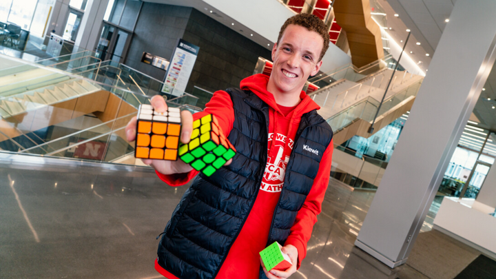 William McDavid, a first-year student, holds two Rubik's Cubes in his hand as he smiles for a photo.