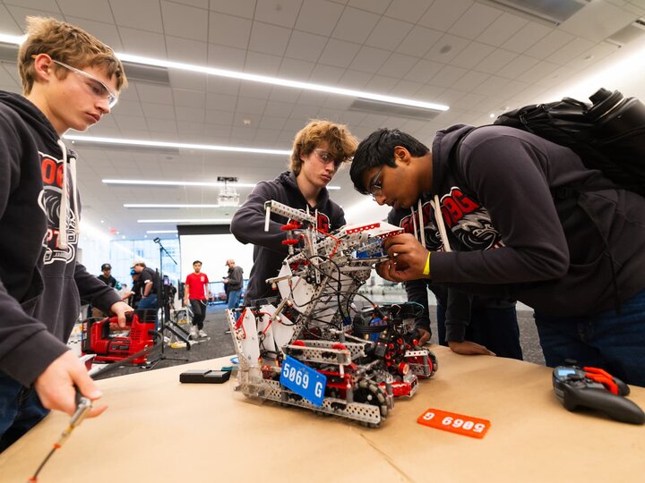 Three students working on a robot.