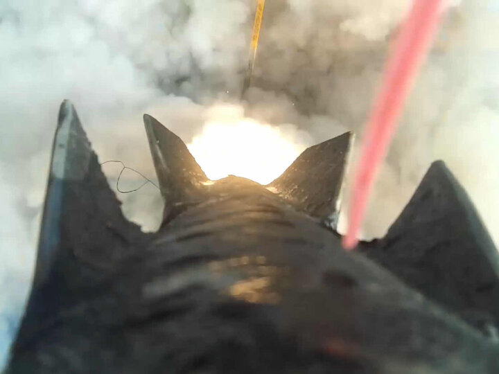 Rocket launches upward surrounded by white smoke and dynamic motion from its ignition exhaust.