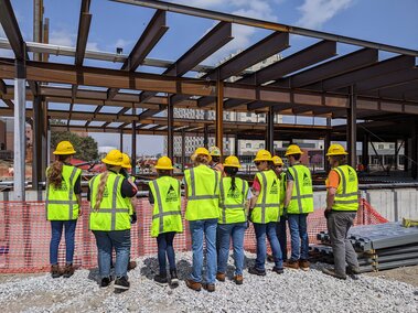Scholars looking at the building site for Kiewit Hall