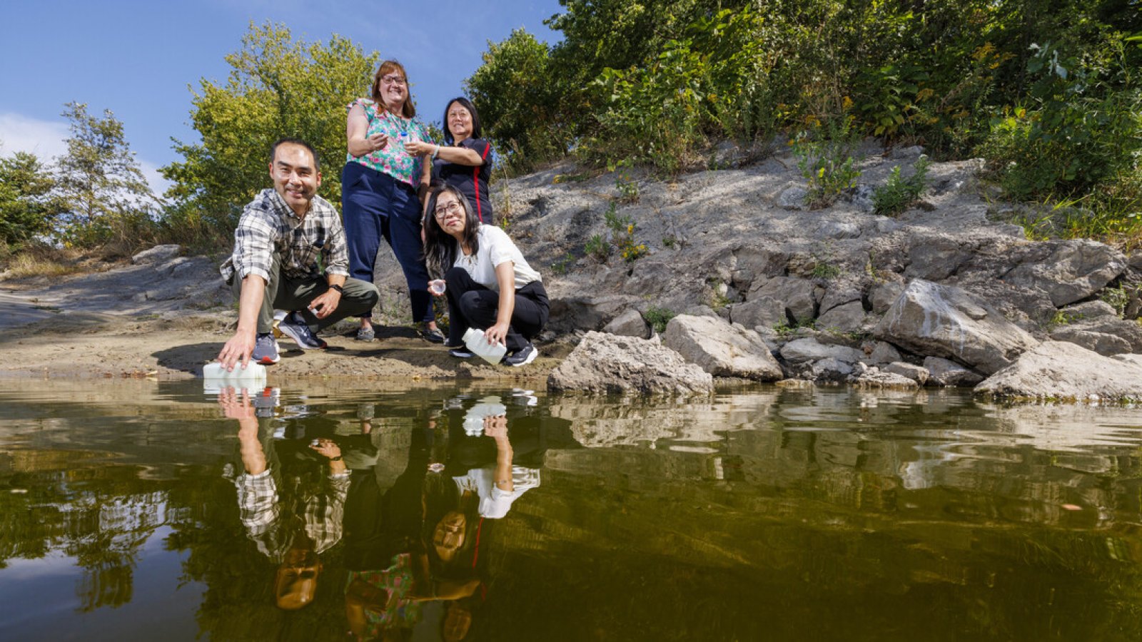 Xu Li (front left), Bing Wang (front right), Shannon Bartelt-Hunt (back left) and Yusong Li (back right) collect and examine water samples from the Elkhorn River near Waterloo, Nebraska, as part of the EPA research project. (Craig Chandler / University Communication and Marketing)