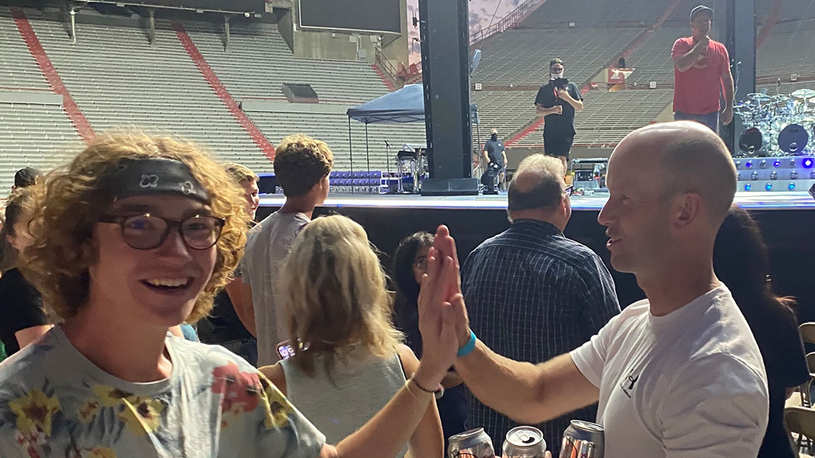 Senior mechanical and materials engineering student Carson Emeigh gets a high five during soundcheck as Garth Brooks talks to the crowd on stage behind him.