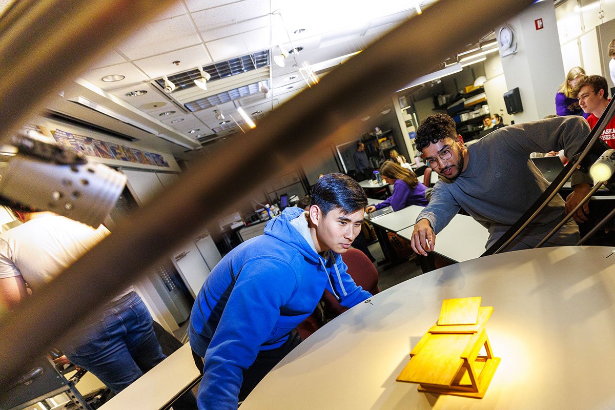 Two male students work on a large metal table in the lighting lab at PKI
