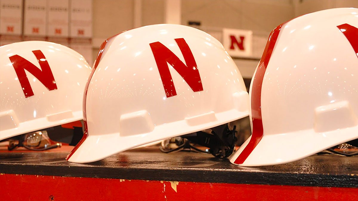 Three white hardhats with red N on the sides