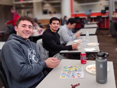 Students sitting at tables playing games