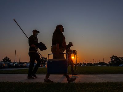 Two people walk at sunrise to do water testing